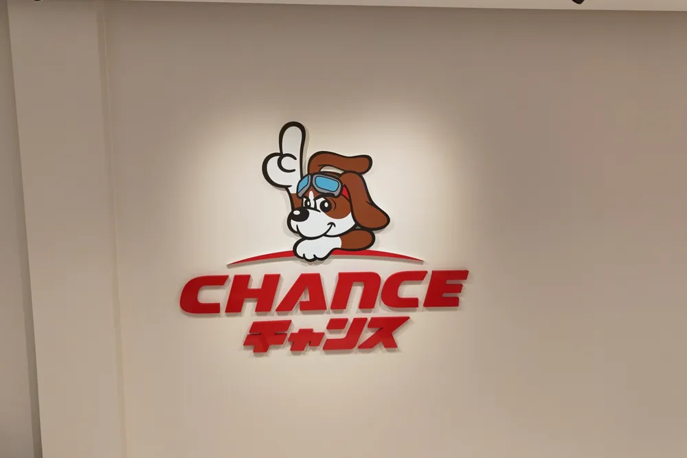 チャンス船橋店の店内の壁にある、犬のキャラクターと CHANCE のロゴ