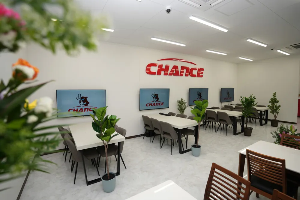 チャンス神栖2号店の店内。壁の CHANCE のロゴと、テーブルごとの大型モニター