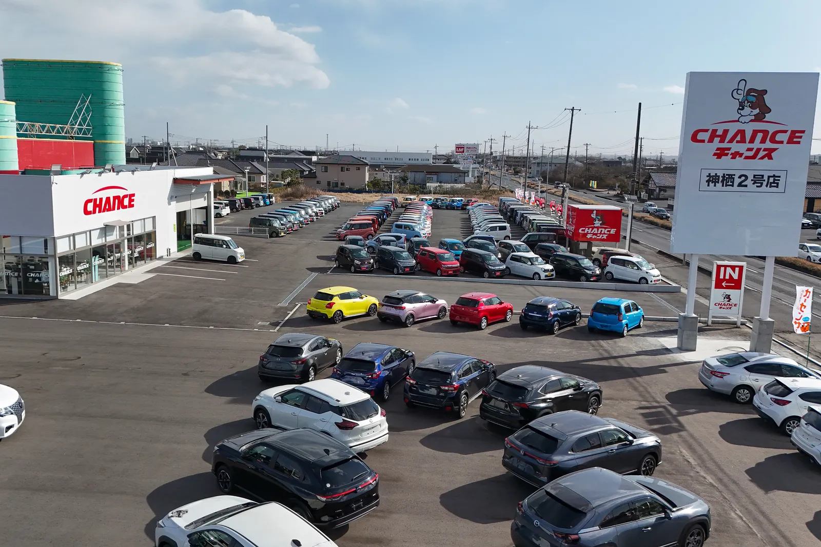 チャンス神栖2号店の、お店の建物と大きな看板。手前に展示車が並ぶ