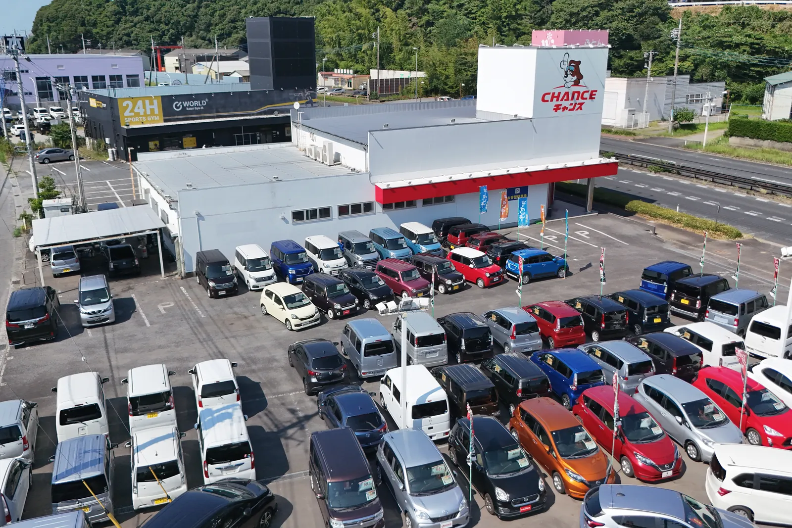 チャンス佐原店を上から見たところ。白い店舗と犬のマークの看板、展示車が並ぶ展示場