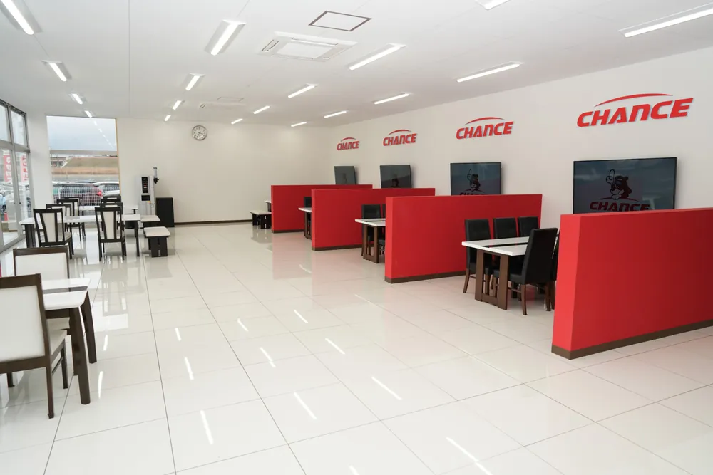 チャンスつくば店の店内。赤い仕切りの商談スペースと、テーブル席