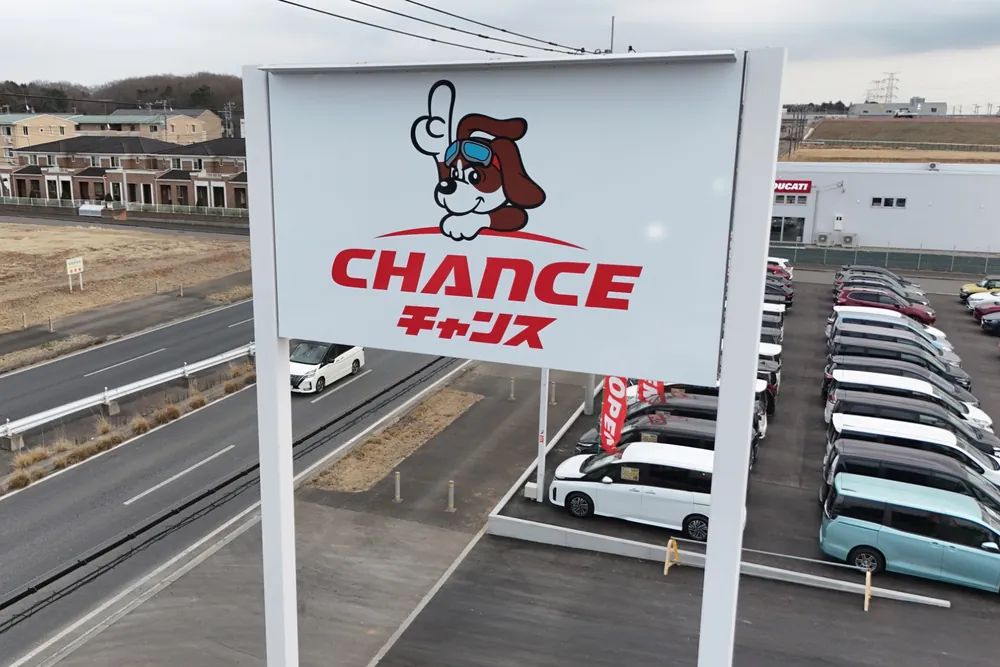 チャンスつくば店の道路沿いに立つ、犬のキャラクターの看板